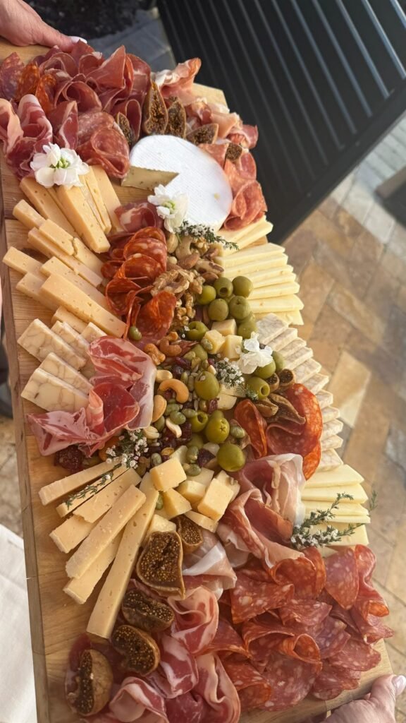 Charcuterie board with sliced cheeses, cured meats and crackers