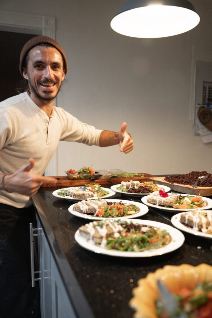 Chef Bruno Di Benedetto in a kitchen beside finished plated courses