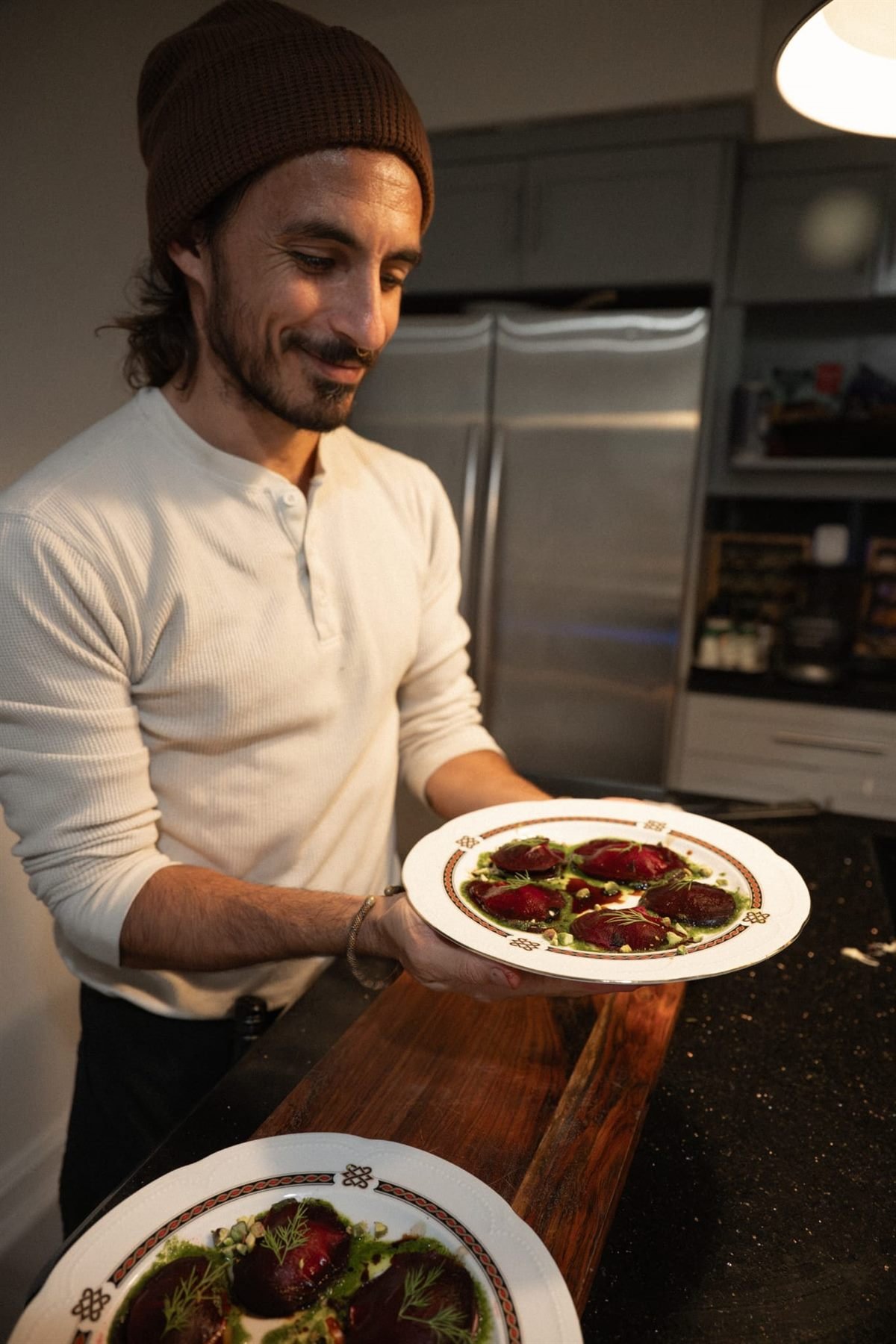 Chef Bruno Di Benedetto holding a finished plate in a Miami kitchen