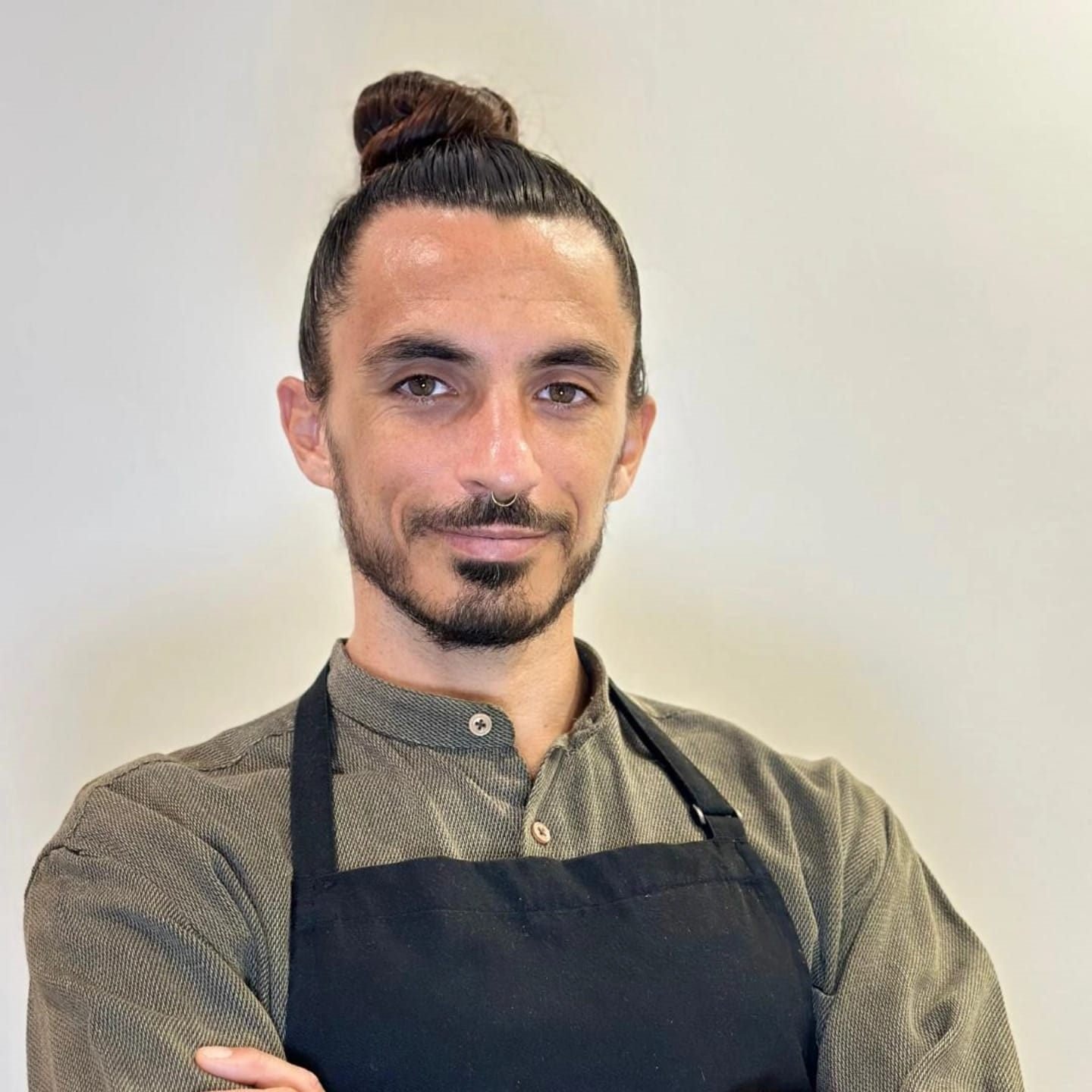 Studio portrait of Bruno Di Benedetto, holistic private chef in Miami, in a chef's apron