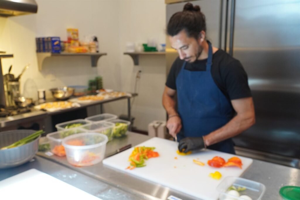 Chef slicing peppers and carrots during service prep