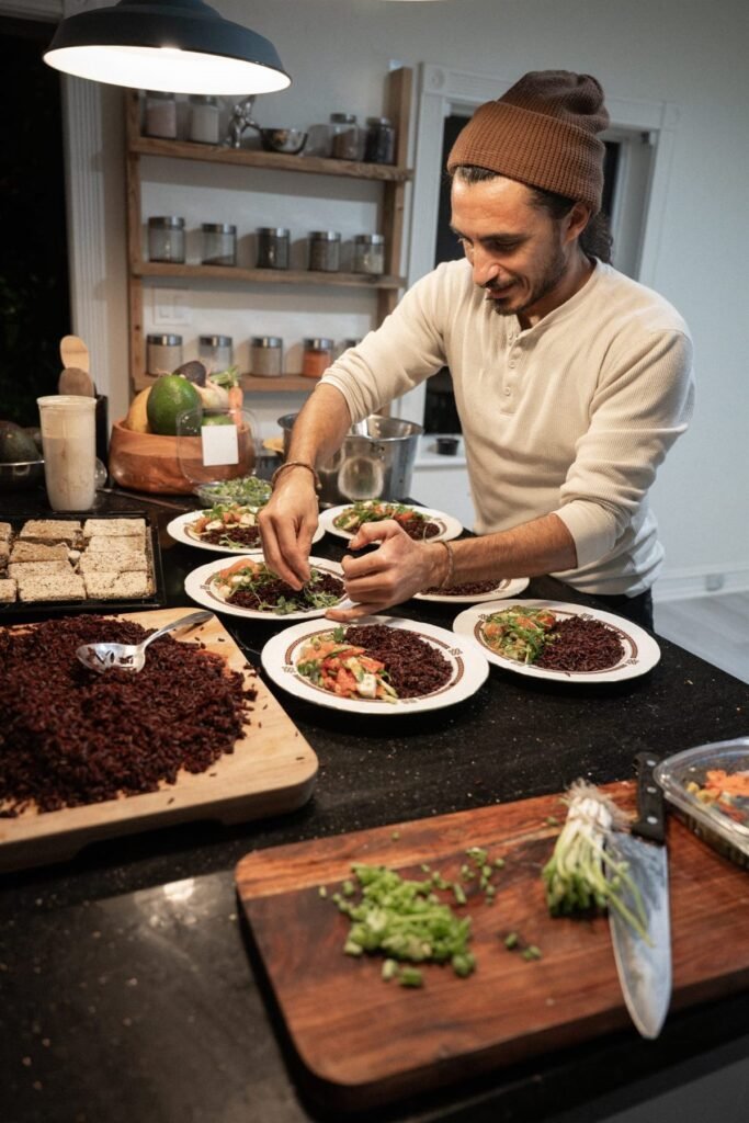 Chef plating multiple dinner courses at a kitchen counter