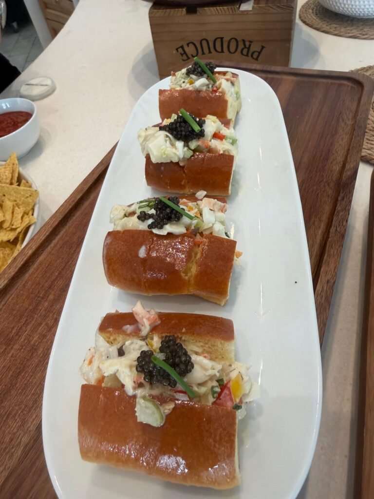 Crostini topped with burrata and herbs on a white platter