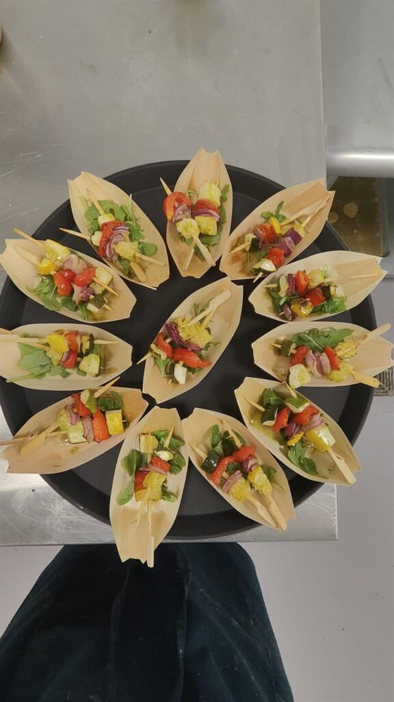 Endive leaves filled with chopped salad arranged on a dark platter