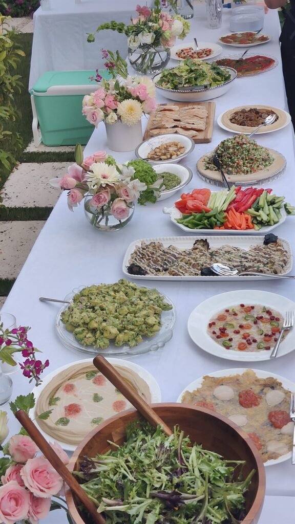 Outdoor buffet spread with salads, dips and platters