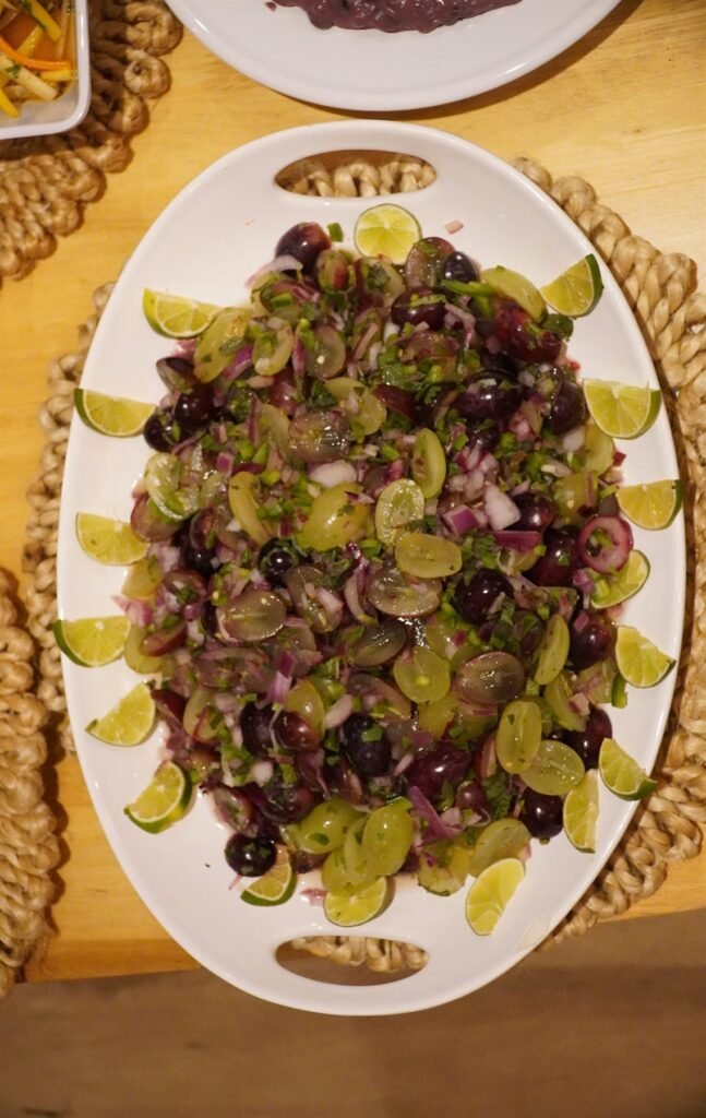Oval platter of grapes, greens and citrus slices