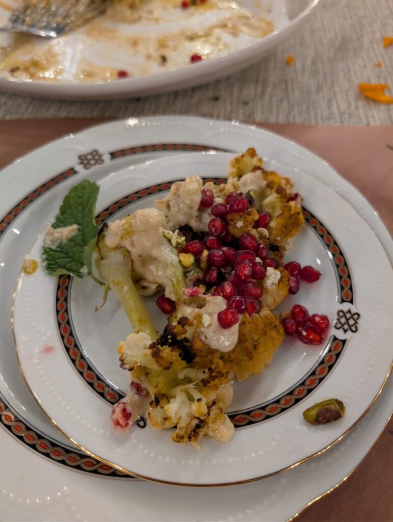 Plated dessert with pomegranate seeds served outdoors at night