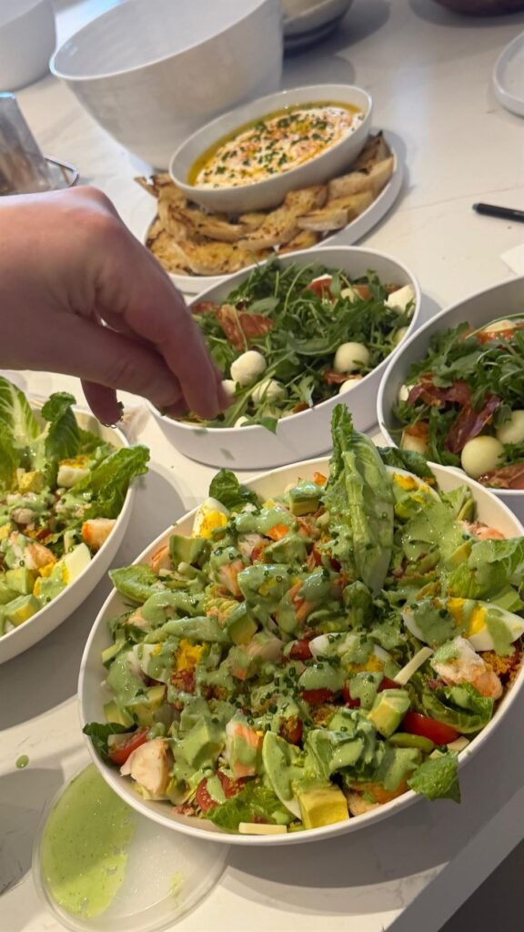 Large serving bowls of dressed seasonal salad
